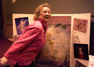 Hostess Margaret Kerry poses in front of a Tinkerbell board.